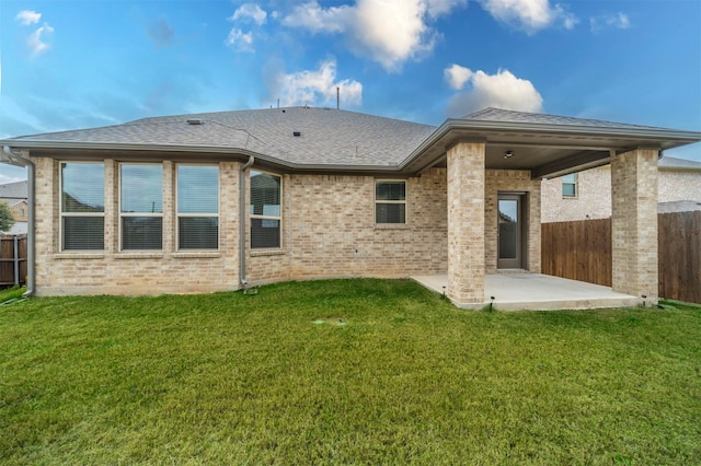 rear view of house with a yard and a patio