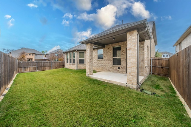 back of property with a patio area and a yard