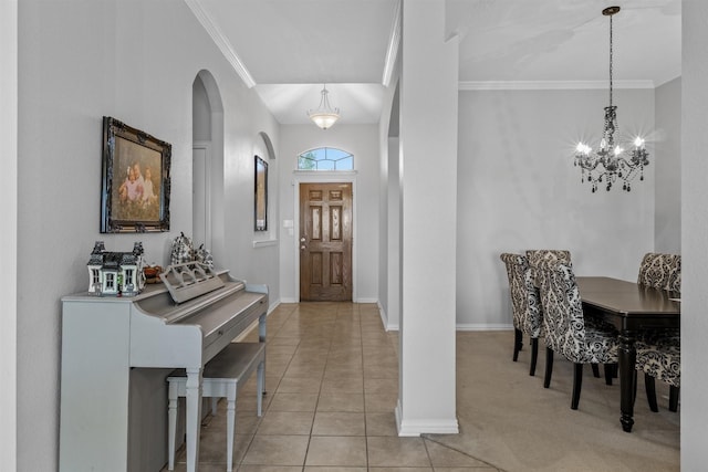 entrance foyer with an inviting chandelier, ornamental molding, and light tile patterned floors