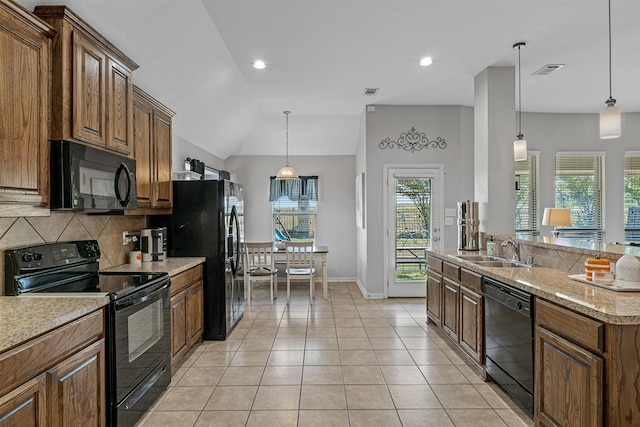 kitchen featuring tasteful backsplash, decorative light fixtures, sink, and black appliances