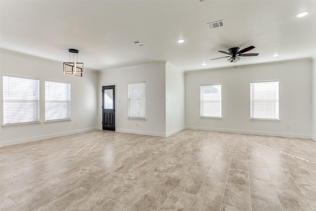 interior space with ceiling fan with notable chandelier and ornamental molding