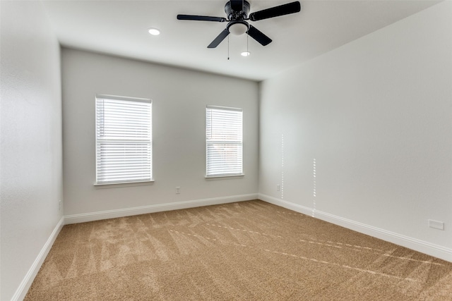 spare room featuring ceiling fan and light colored carpet