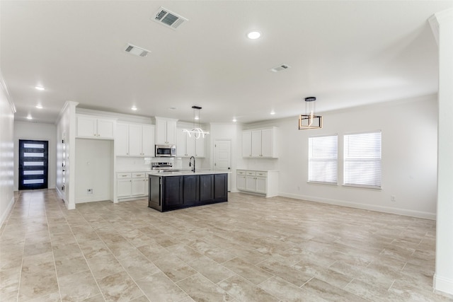 kitchen with white cabinets, hanging light fixtures, an island with sink, and appliances with stainless steel finishes