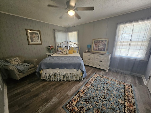 bedroom featuring dark hardwood / wood-style floors, a textured ceiling, ceiling fan, and wood walls