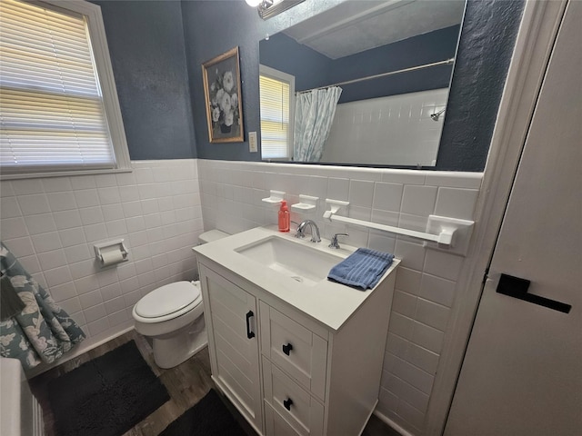 bathroom featuring walk in shower, toilet, tile walls, vanity, and hardwood / wood-style flooring