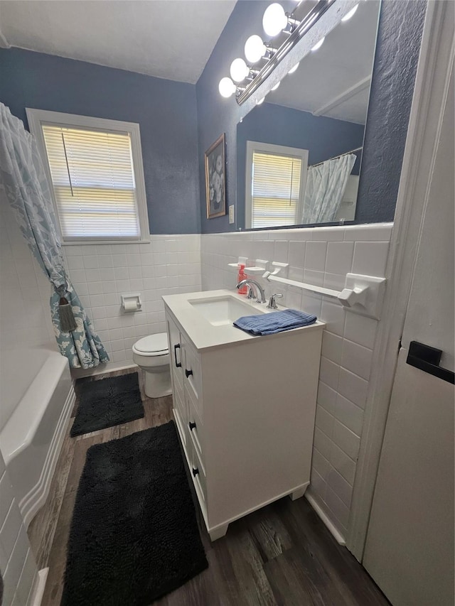 bathroom featuring tile walls, vanity, hardwood / wood-style flooring, and toilet