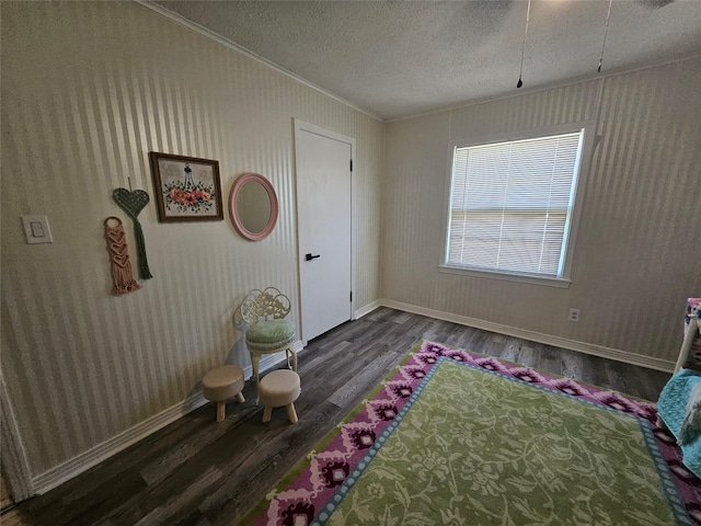 recreation room with crown molding, dark hardwood / wood-style floors, and a textured ceiling