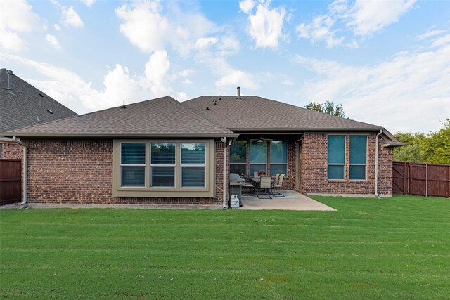 rear view of property with a patio area, ceiling fan, and a yard