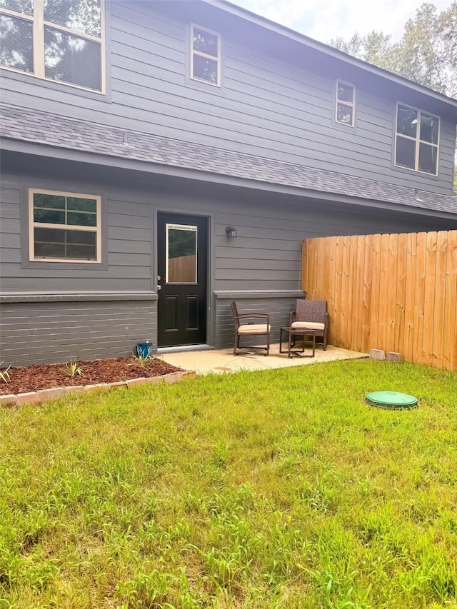 back of house featuring a lawn and a patio area