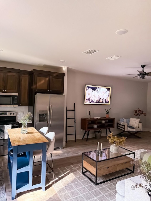 living room with hardwood / wood-style flooring and ceiling fan