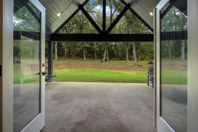 doorway to outside featuring concrete flooring and lofted ceiling