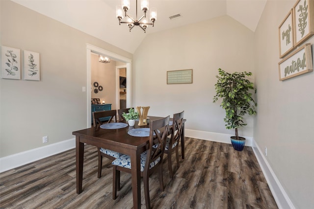 dining space with lofted ceiling, dark wood-type flooring, and a chandelier