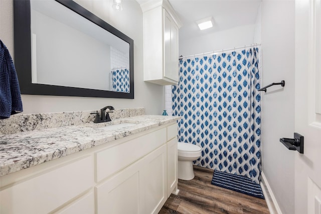 bathroom featuring hardwood / wood-style flooring, vanity, a shower with curtain, and toilet