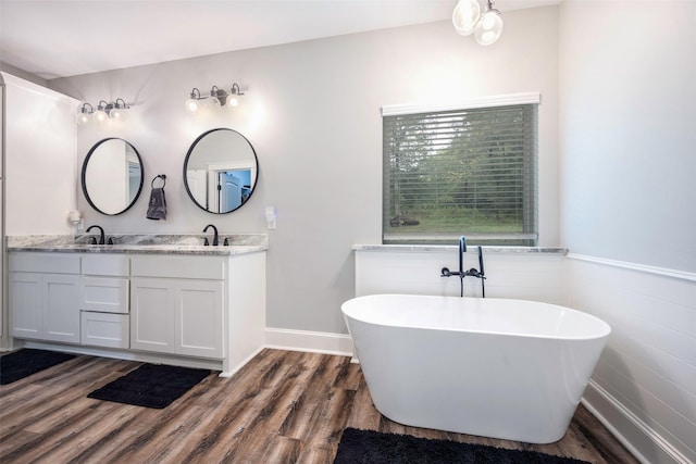 bathroom featuring vanity, hardwood / wood-style floors, and a tub