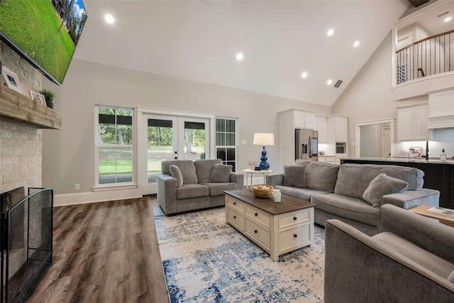 living room with french doors, a fireplace, high vaulted ceiling, and hardwood / wood-style floors