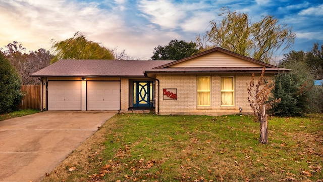 single story home with a garage and a lawn