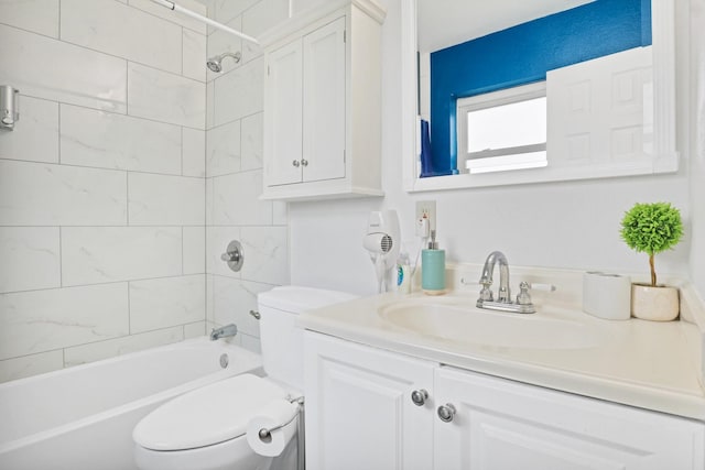 full bathroom with vanity, tiled shower / bath combo, and toilet