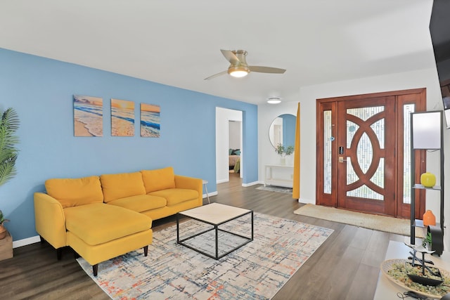 living room with ceiling fan and dark hardwood / wood-style flooring