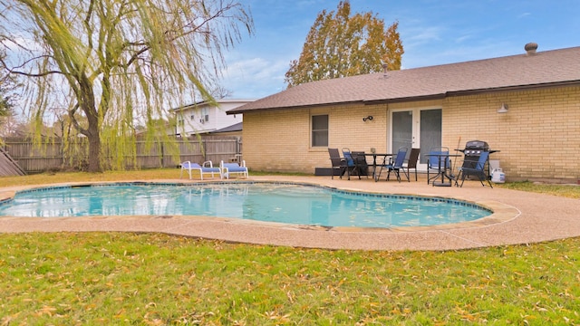 view of pool featuring grilling area, a patio, and a lawn