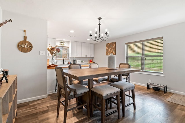 dining room with dark hardwood / wood-style flooring, a notable chandelier, and sink