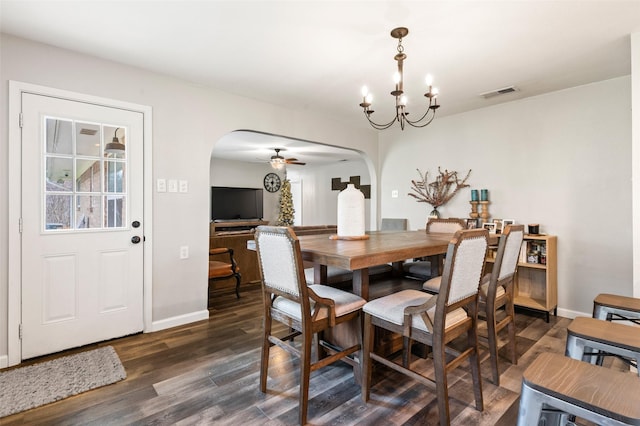 dining space with dark wood-type flooring and ceiling fan with notable chandelier