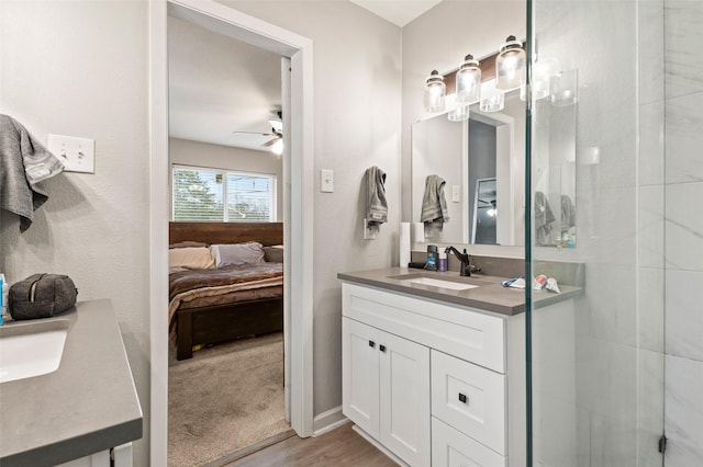 bathroom featuring ceiling fan, vanity, a shower with shower door, and hardwood / wood-style flooring