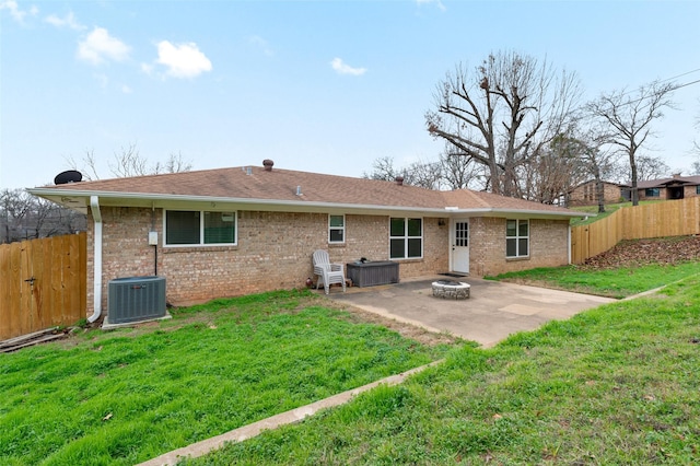 back of property featuring a lawn, a patio, central AC unit, and an outdoor fire pit