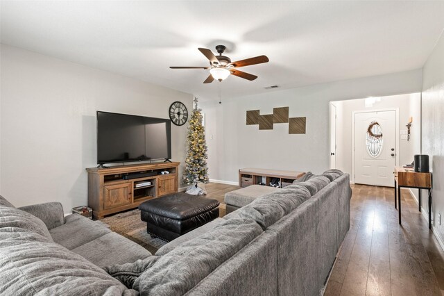 living room featuring ceiling fan and dark wood-type flooring