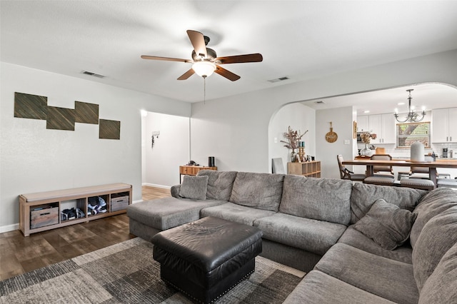 living room featuring dark hardwood / wood-style floors and ceiling fan with notable chandelier