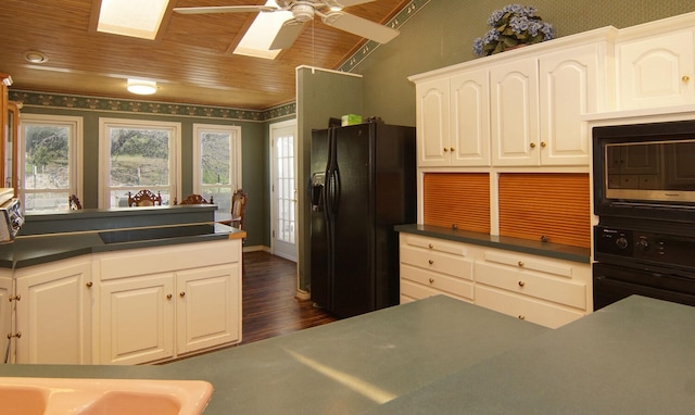 kitchen with black appliances, a skylight, ceiling fan, white cabinetry, and wood ceiling