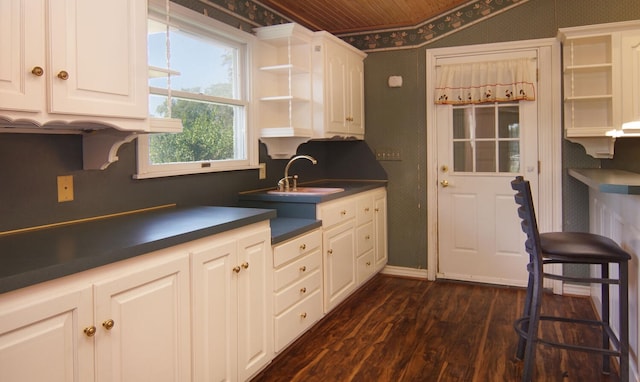 kitchen featuring white cabinets, dark hardwood / wood-style floors, wood ceiling, and sink