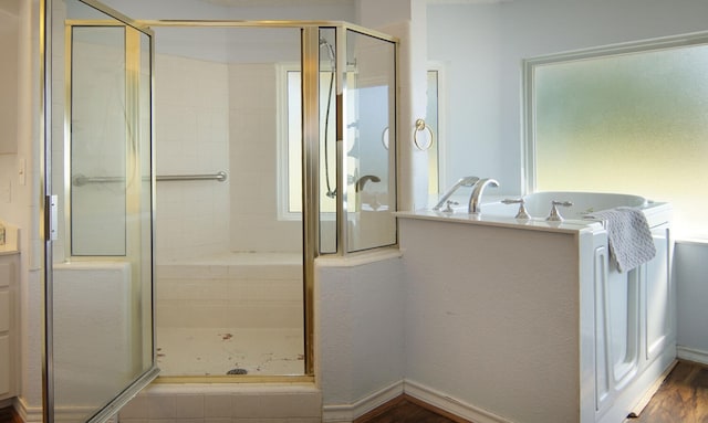 bathroom featuring hardwood / wood-style flooring and plus walk in shower