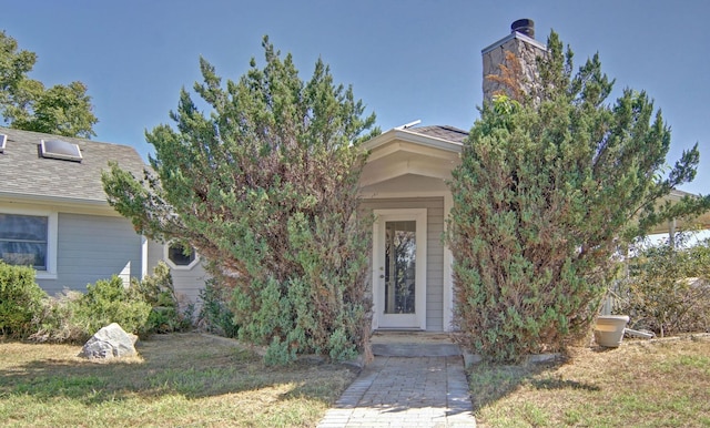 view of property hidden behind natural elements featuring a front yard