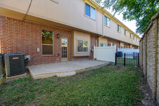 back of property featuring a lawn, cooling unit, and a patio