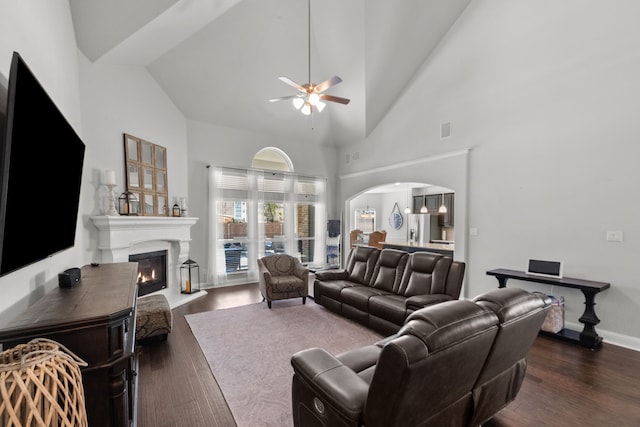 living room featuring ceiling fan, dark wood-type flooring, and high vaulted ceiling