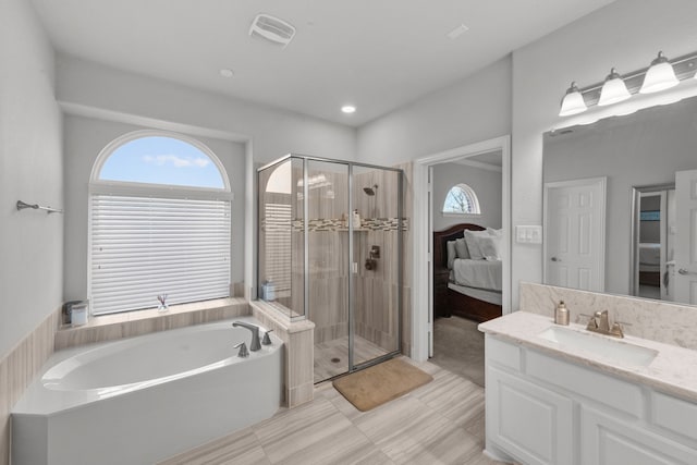 bathroom with vanity and shower with separate bathtub