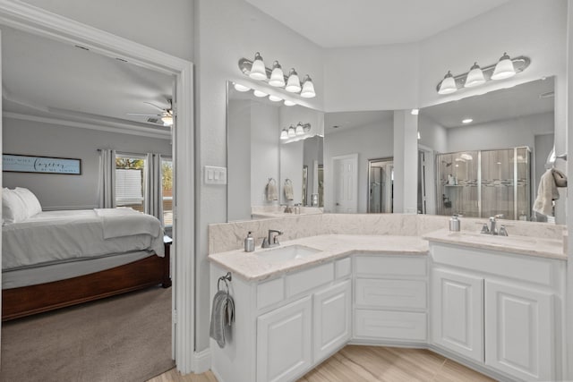 bathroom with a shower with door, vanity, and ceiling fan