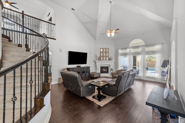 living room featuring dark hardwood / wood-style flooring, high vaulted ceiling, and ceiling fan