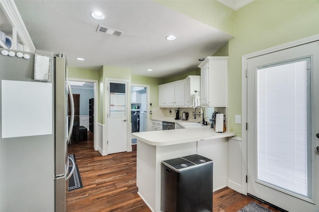 kitchen featuring white cabinets, sink, dark hardwood / wood-style floors, appliances with stainless steel finishes, and kitchen peninsula