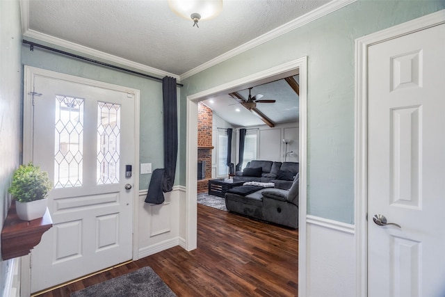 entryway featuring ceiling fan, dark wood-type flooring, a brick fireplace, crown molding, and a textured ceiling