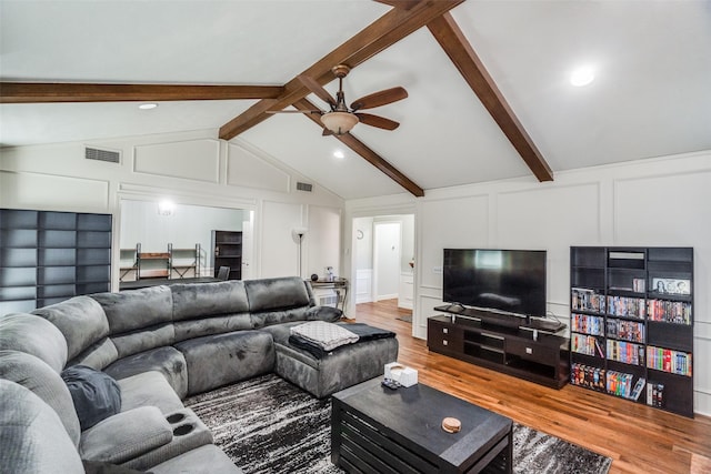 living room featuring vaulted ceiling with beams, ceiling fan, and wood-type flooring