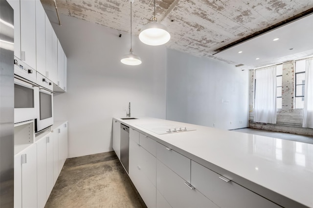 kitchen featuring white cabinetry, sink, hanging light fixtures, and white appliances