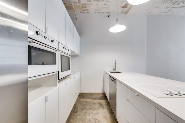 kitchen with white cabinetry, sink, pendant lighting, and appliances with stainless steel finishes