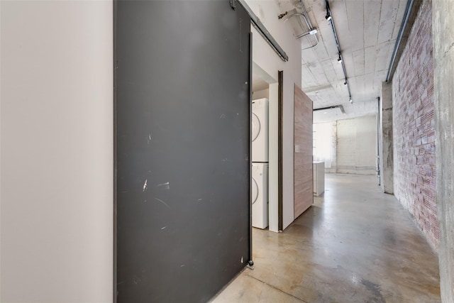 hallway featuring stacked washer and dryer