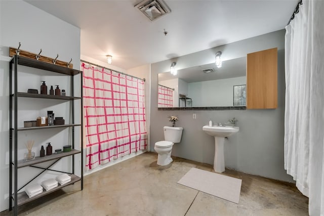 bathroom with concrete floors and toilet