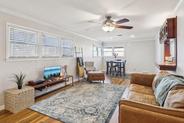 living room featuring wood-type flooring, ceiling fan, and ornamental molding