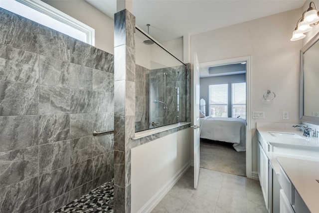 bathroom with tile patterned floors, vanity, and a tile shower