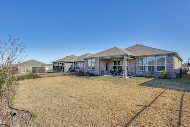 rear view of house featuring a yard and a patio