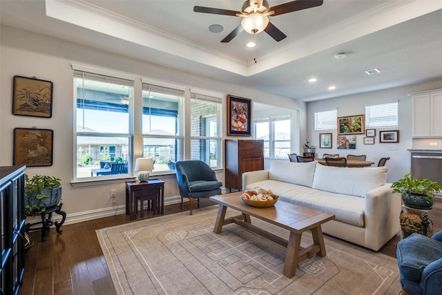 living room with a tray ceiling, ceiling fan, wood-type flooring, and ornamental molding