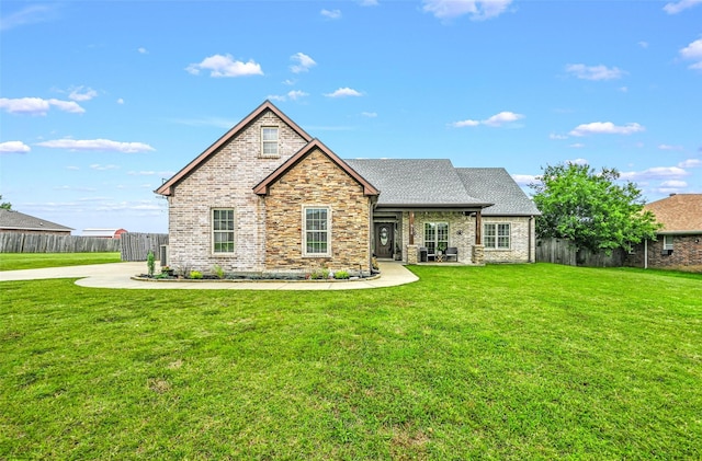 view of front facade with roof with shingles, a front yard, and fence